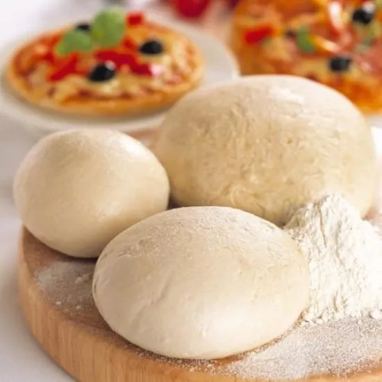 A ball of pizza dough on a floured counter