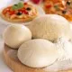 A ball of pizza dough on a floured counter